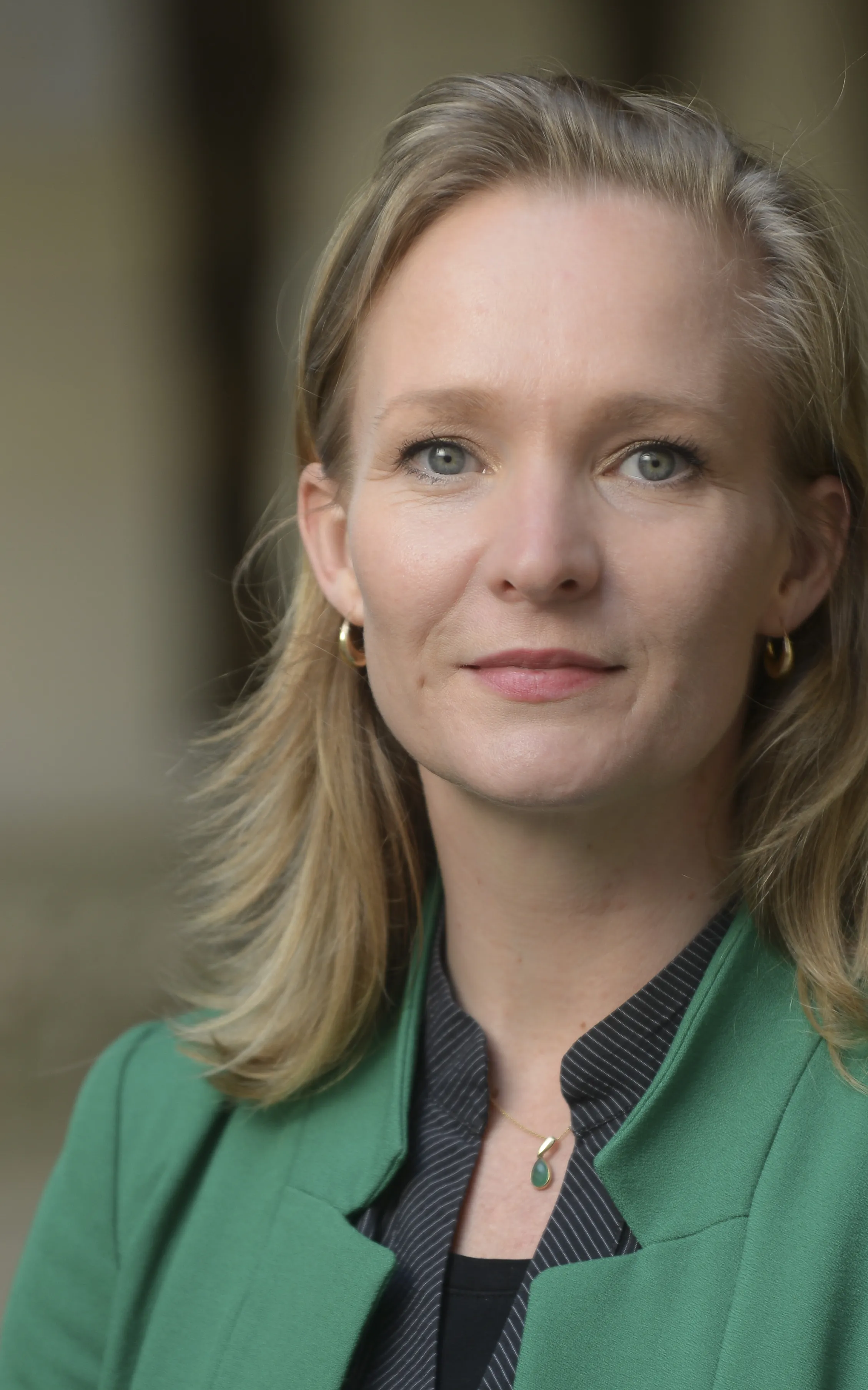 Vrouw, blond haar, groen jasje
