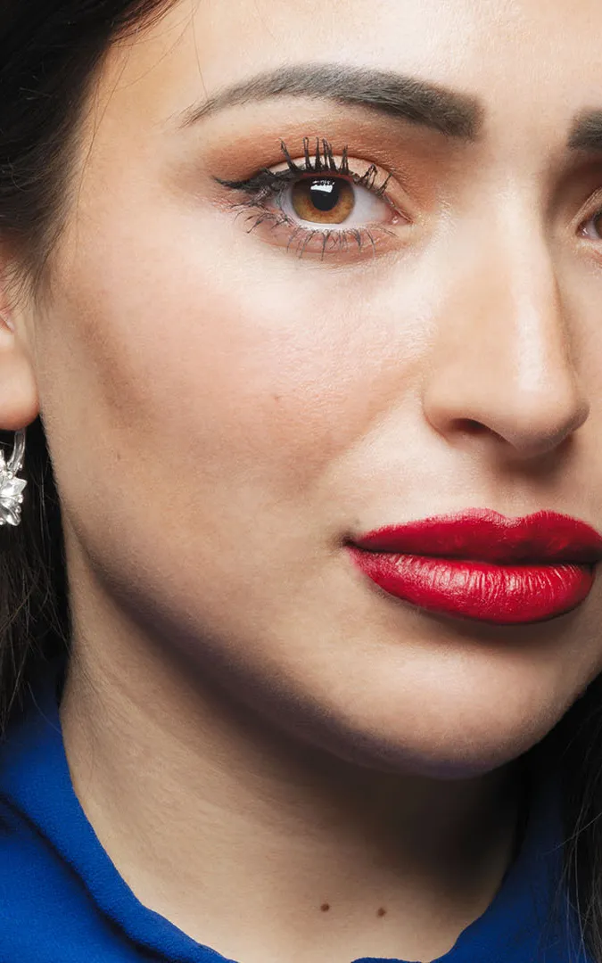 Jonge vrouw met rode lippen en donker haar.